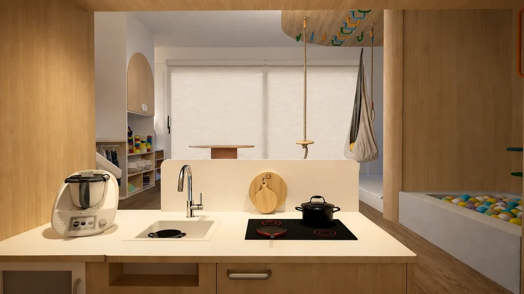 Cocina infantil de madera integrada en sala de juegos con zona de movimiento y piscina de bolas